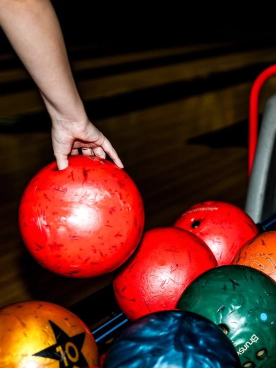 girl picking up bowling ball