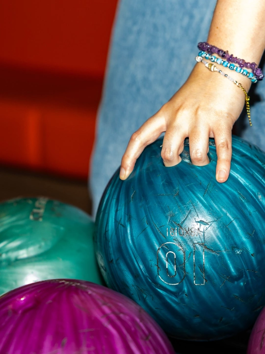 girl picking up bowling ball at woking superbowl
